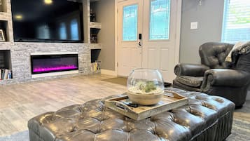 Télévision, cheminée, baby-foot, livres