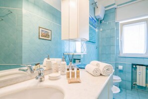 Een badkamer met een grote spiegel, een wastafel en toiletartikelen.