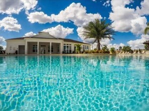 Una piscina cristalina con un edificio al fondo.