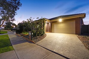 Welcome to a serene home with a well-maintained driveway and a beautifully landscaped entrance.
