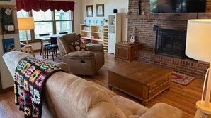 Ein gemütliches Wohnzimmer mit Kamin, Ledersofa und Couchtisch.