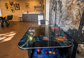 A table with a space-themed design, a kitchen area, and a rustic wall.