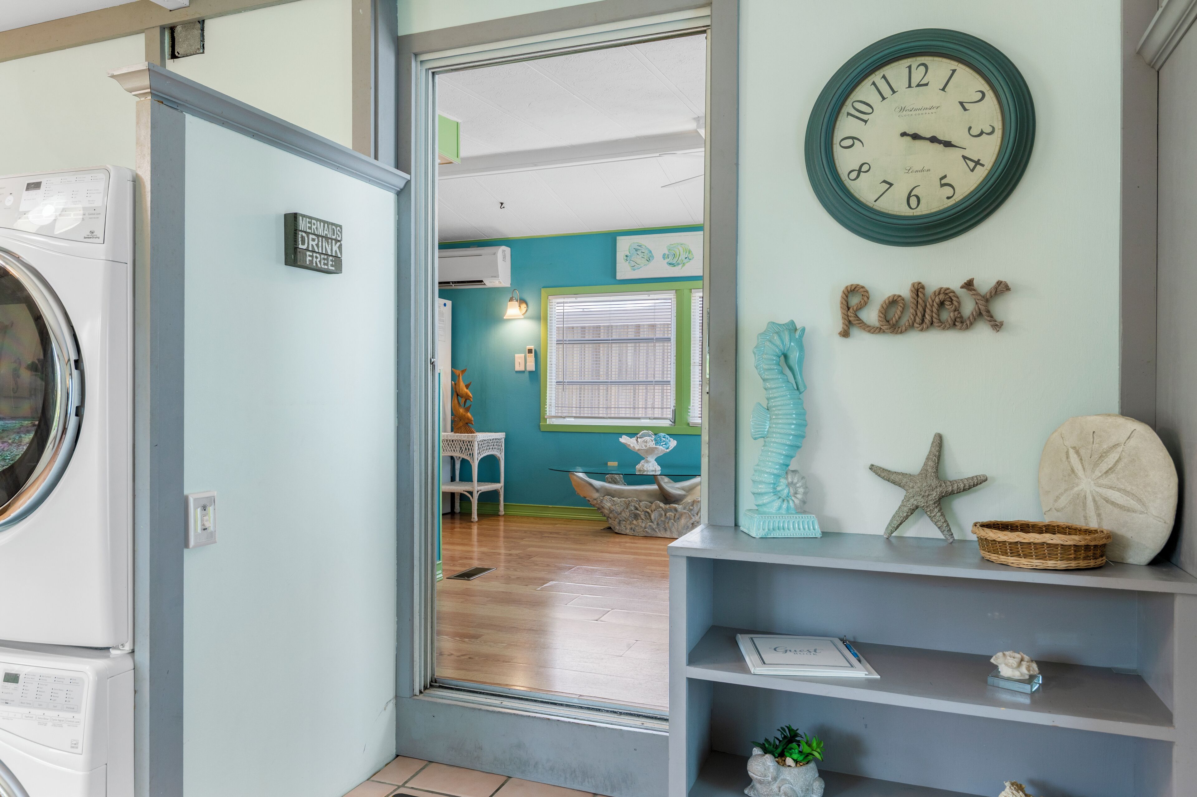 A laundry room with a sign that says "Mermaids Drink Free."