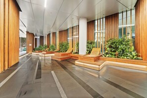 Experience the welcoming atmosphere of our lobby, featuring a polished tile floor, wooden paneling, and large windows.