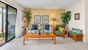 A living room with a sofa, two armchairs, a coffee table, and a ceiling fan. - Cozy ground floor condo, lush lanai, dining nearby (Kihei)