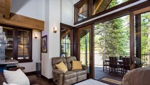 Una sala de estar acogedora con chimenea, un sofá y un comedor con mobiliario de exterior.
