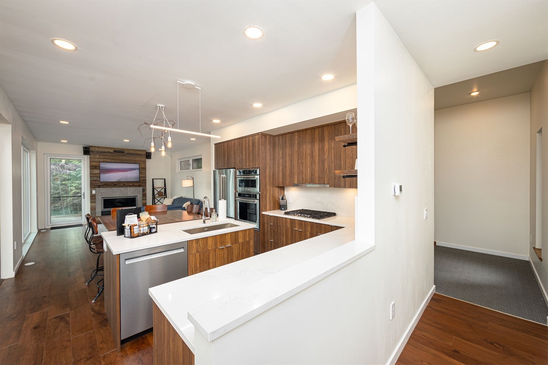 A modern kitchen with wooden cabinets, a white countertop, and built-in appliances.