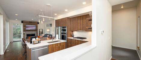 A modern kitchen with wooden cabinets, a white countertop, and built-in appliances.
