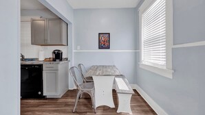 A compact kitchen with white cabinets, a dishwasher, and a countertop with a coffee maker. - Evergreen Historic District 1928 Midtown Apartment (Memphis)
