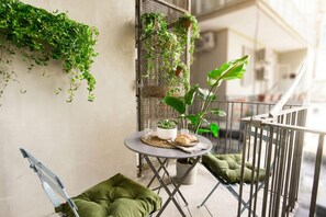 A balcony with a small table, chairs, and potted plants. - Floris - Sophisticated Studio (Bari)