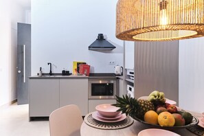 Een oven, kookgerei, borden en bestek, een eettafel