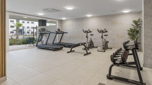A modern gym with treadmills, a bench press, and dumbbells. - Casa de los amigos Sea View Estepona (Málaga)