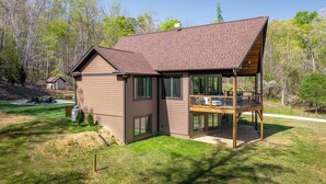 A two-story house with a deck and a covered porch. - Lakeways A-Frame Near Lake James Game Room · Gym · Golf · Fire Pit · Sleeps 10 (Nebo)
