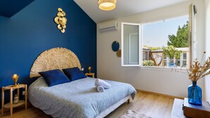 A bedroom with a bed, a window, a ceiling light, and a view of the outside. - La Perle de Jade by Interhome (Pornic)