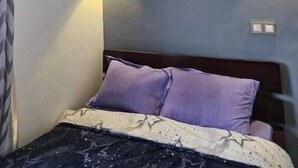 Une chambre à coucher avec un lit, une horloge et deux lampes fixées au mur.