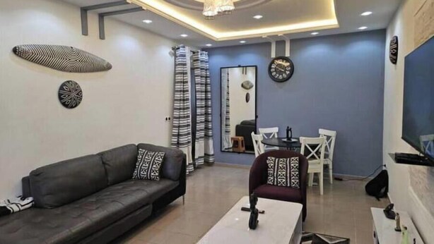 Un salon moderne comprenant un canapé, une table basse et un coin repas avec des chaises et une table.