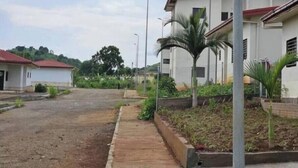 Un quartier résidentiel avec des maisons, une route asphaltée et un trottoir.