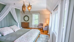Un dormitorio con cama, una silla, cómoda y ventana.