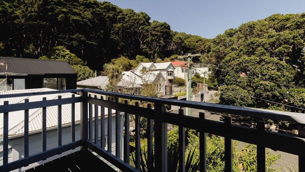A residential area with houses surrounded by dense forest.