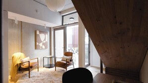 A modern living room with a wooden ceiling, a large window, a sofa, a chair, and a small table. - Executive 2BR Designer Townhouse + Rooftop Oasis (Wellington)