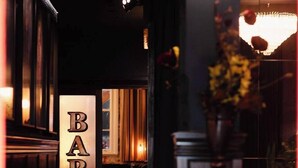 A bar area with a sign reading "BAR" and a chandelier. - Spacious 2BR Oasis in Central Wellington w Terrace (Auckland)
