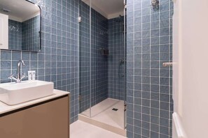 Chuveiro, secador de cabelo, toalhas de banho, shampoo