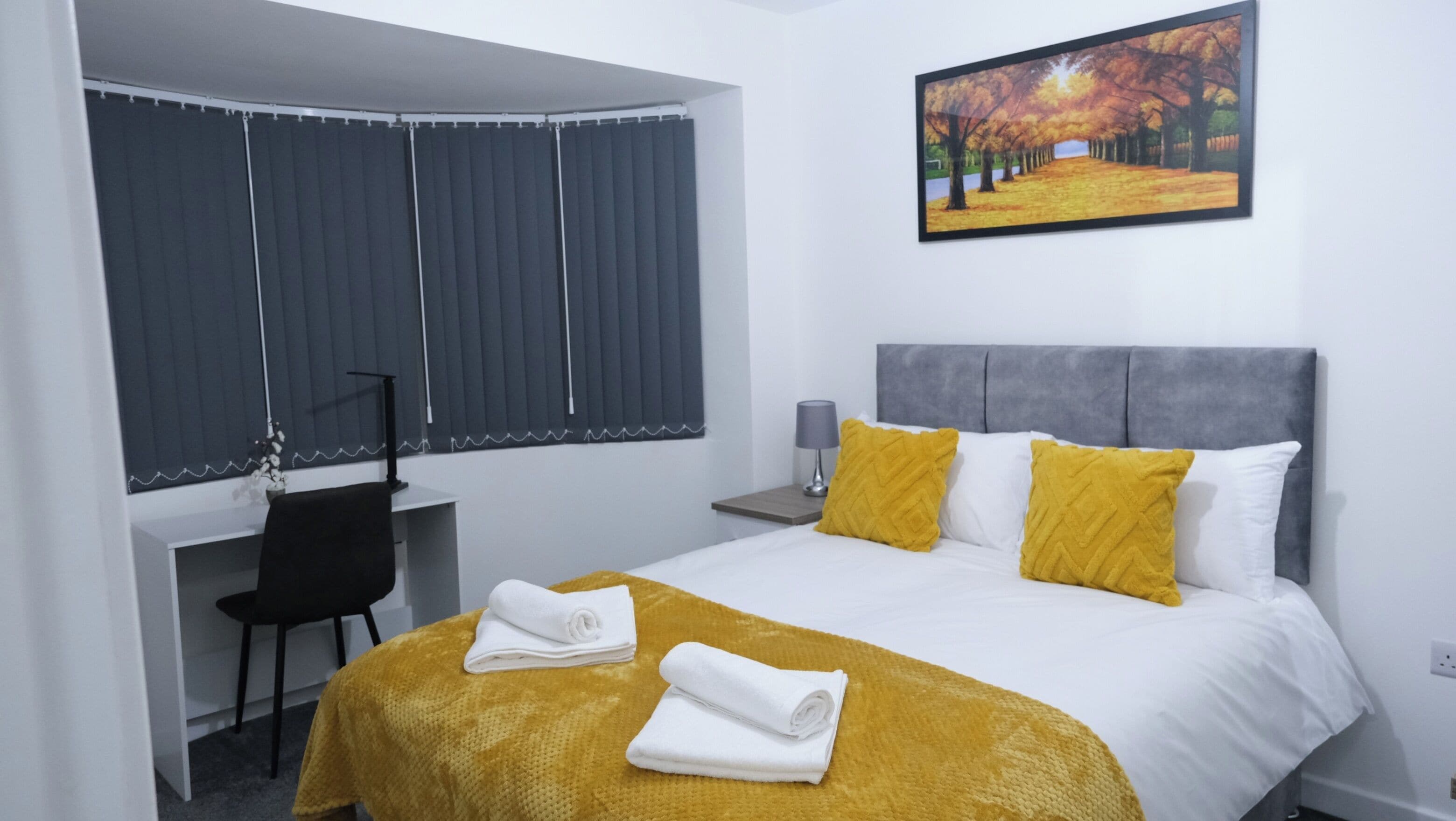 Une chambre d’hôtel avec un lit, un bureau et une chaise.