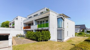 A modern two-story residential building with balconies, a covered outdoor area, and a well-maintained lawn. - Blueground | Senningerberg, balcony, nr Parc de Merl (Luxembourg)