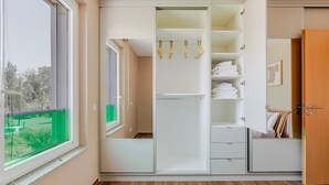 A bedroom with a large wardrobe, a window with a view, and a wooden floor. - Blueground | Senningerberg, balcony, nr Parc de Merl (Luxembourg)