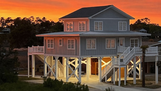 A two-story house with a balcony and a covered porch. - Cypress Cottage - Marshfront in Garden City Beach! (Garden City Beach)