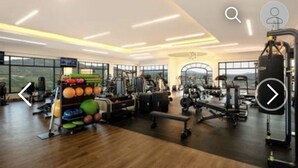 Une salle de sport spacieuse équipée de divers appareils d’exercice, d’un support à poids et d’un banc.