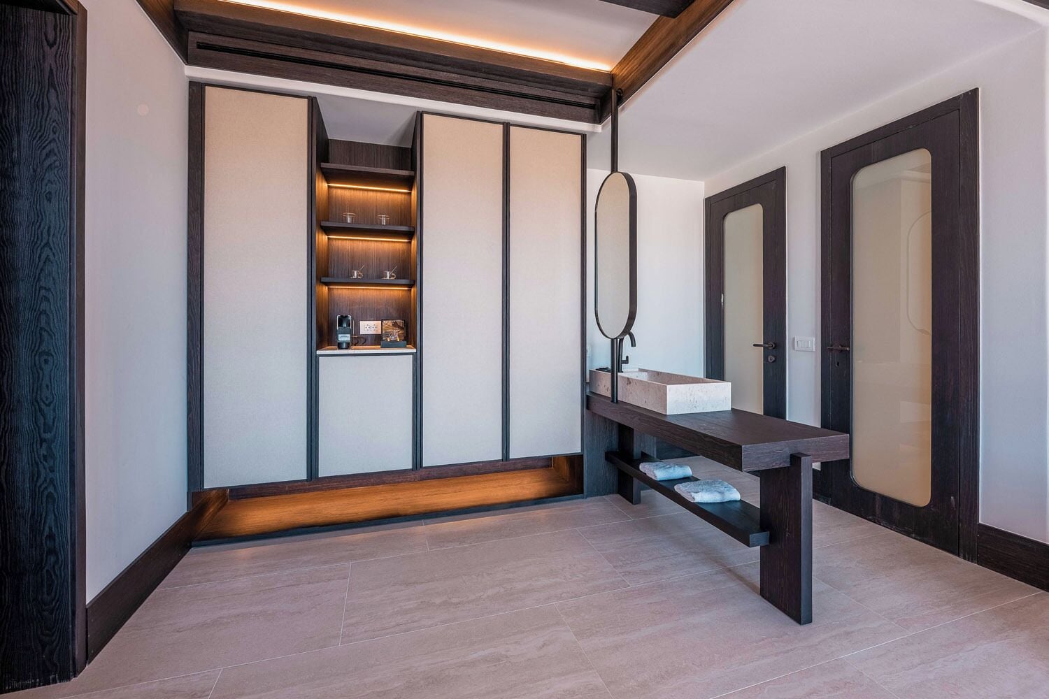 A modern bathroom with a vanity, a mirror, and built-in storage.