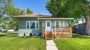 A single-story house with a front porch, a small front yard, and a visible mailbox. - Charming 1950's Home Near Downtown, Fenced Yard, Pet Friendly! (Rapid City)