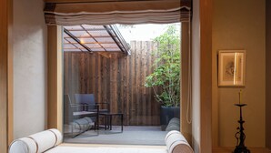 Une pièce donnant sur une clôture en bois, avec une plante en pot et un tableau encadré accroché au mur.