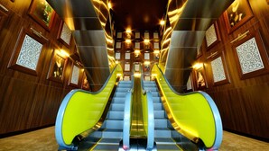 A modern elevator with a central staircase, surrounded by wooden paneling and decorative tiles.