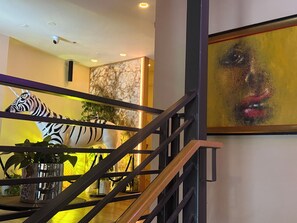 A staircase with a zebra sculpture, a painting, and a plant. - Unicorn Zebra (Tucson)