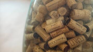 Una botella de vidrio transparente llena de numerosos tapones de vino.