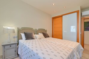 Une chambre à coucher comprenant un lit, une table de chevet, une lampe et un placard avec une porte coulissante.