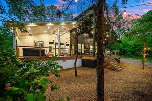 A modern building with a covered outdoor area, a staircase, and string lights.