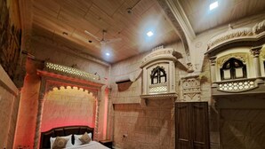 A bedroom with a large bed, a wardrobe, and decorative arches. - Batra Guest House (Varanasi)
