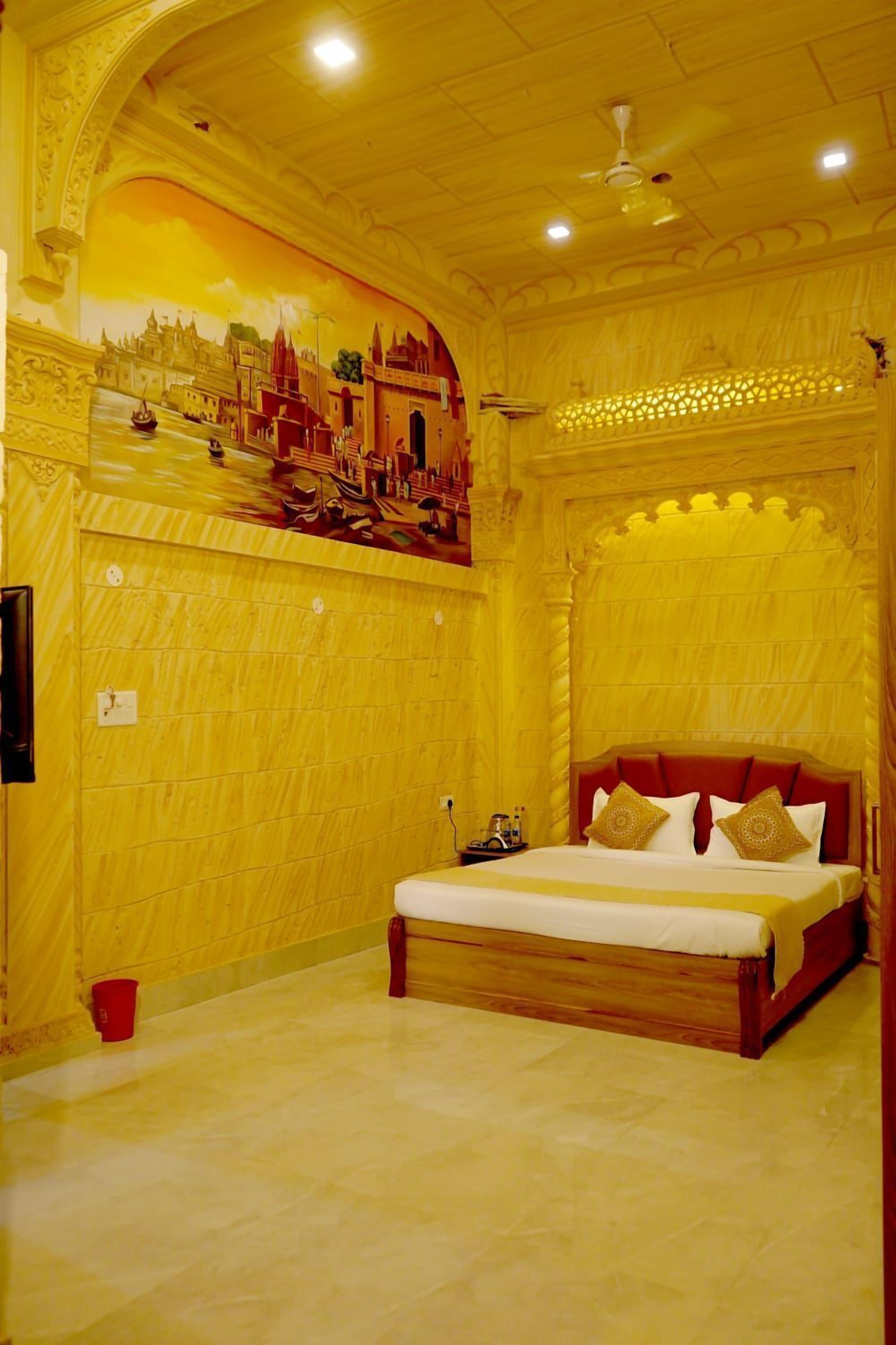 A bedroom with a large bed, a ceiling fan, and a mural on the wall.