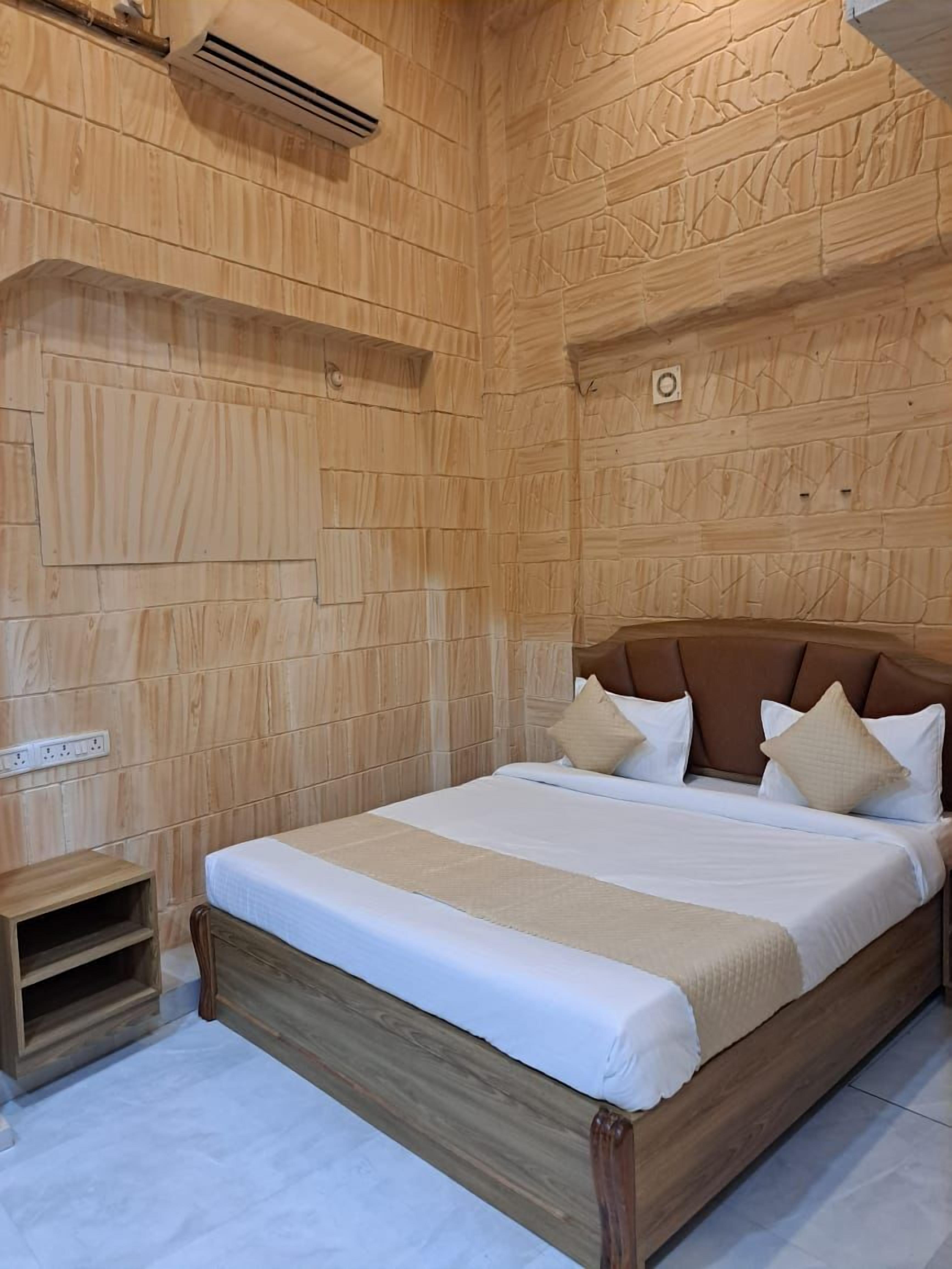 A wooden-paneled bedroom with a bed, pillows, and a small wooden nightstand.