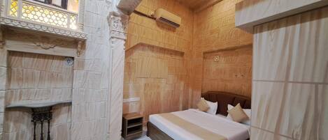 A bedroom with a wooden headboard, a bed with white bedding, a nightstand, and a decorative wall with a window.