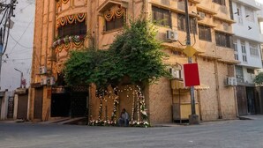 A multi-story building with balconies, air conditioning units, and a street in front. - Batra Guest House (Varanasi)