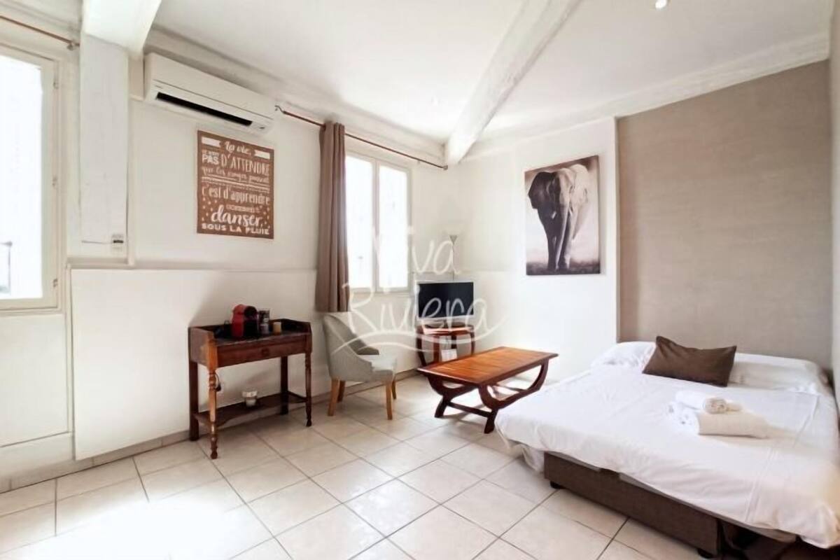 Een slaapkamer met een bed, een bureau, een stoel en een klein tafeltje.
