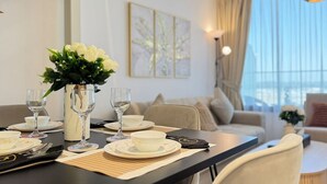 Une table à manger dressée avec des assiettes, des verres et un vase de fleurs.
