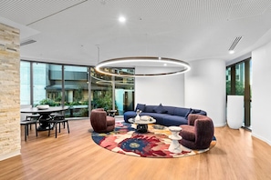 Un espace de détente moderne avec une table basse ronde, des canapés et un tapis à motifs.