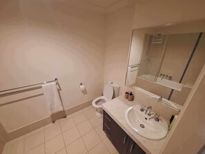 A bathroom with a toilet, sink, mirror, and towel rack. - Cosy, Modern, 4BR Home In Mullumbimby (Mullumbimby)