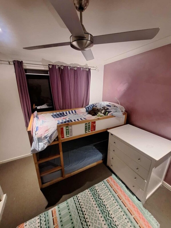 A compact bedroom with a bunk bed, a ceiling fan, a small wardrobe, and a patterned rug. - Cosy, Modern, 4BR Home In Mullumbimby (Mullumbimby)