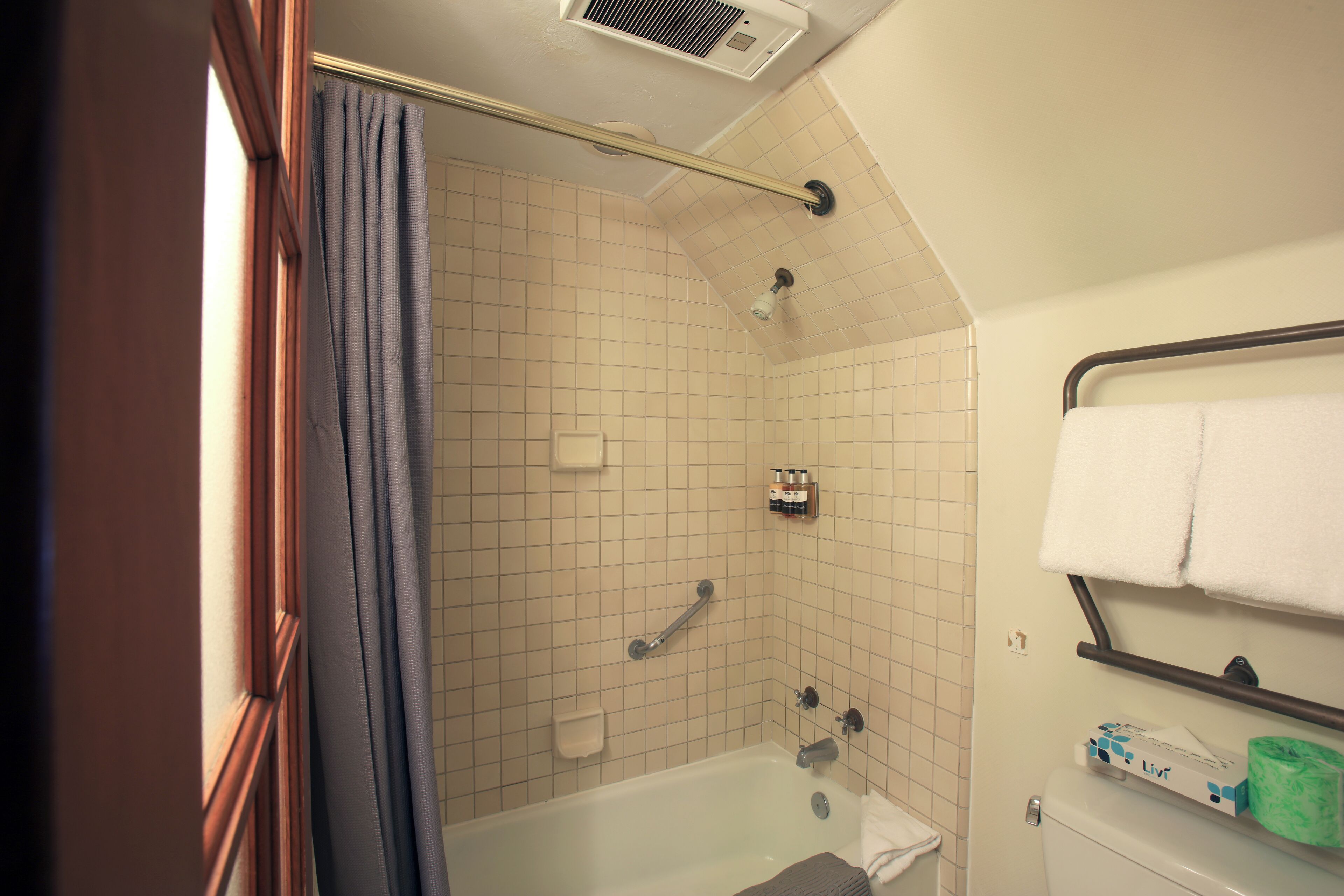 A bathroom with a bathtub, a shower, a toilet, and a towel rack.
